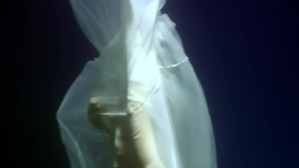 Young woman underwater model in white cloth on background of blue water. — Stock Video