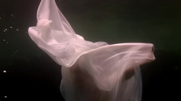 Young woman underwater model in white cloth depicts birth of an angel. — Stock Video