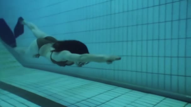 Fille freediver nage dans les nageoires sous l'eau dans la piscine. — Video