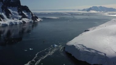 Antarktika 'daki karlı dağların ve buzlu kıyıların 4K Hava Sahası