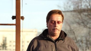 Adam baş ağrısı ve şehir otobüs durağında ani giddiness sokak hissettim.