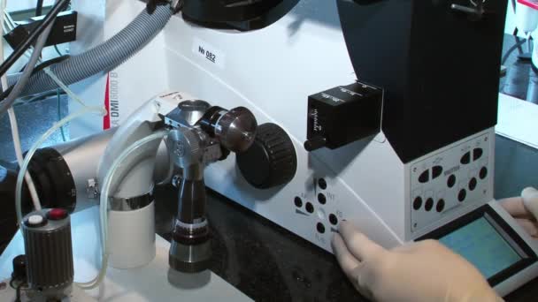 Fruchtbarkeitsmediziner mit Mikroskop, Spritze und Petrischale Befruchtung von Eizellen und Forschung in Reproduktionskliniken. — Stockvideo