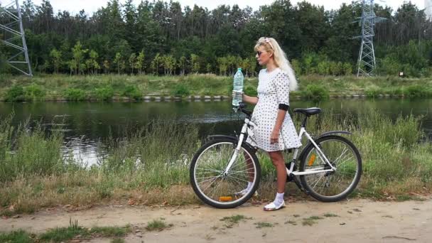 Bella ragazza con i capelli bianchi bevande sexy acqua da una bottiglia. Rallentatore . — Video Stock