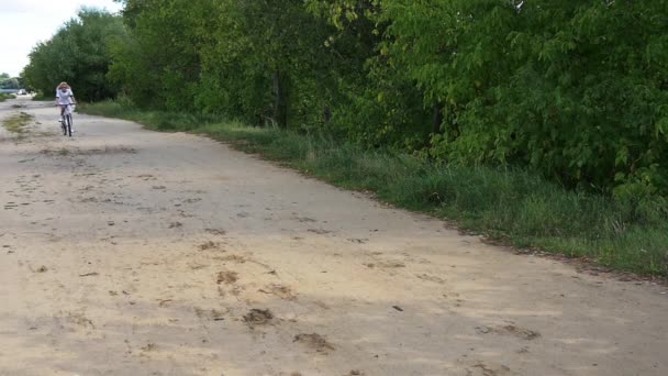 Incroyable fille aux cheveux blancs promenades sexy un vélo sur la route et met ses pieds . — Video