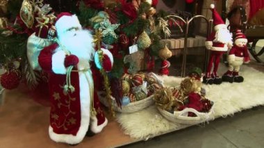 Ağacın altındaki karda komik oyuncak kardan adam. Parıldayan ışıklar arasında Noel ağacında Noel ve Yılbaşı oyuncakları.