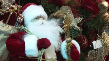 Ağacın altındaki karda komik oyuncak kardan adam. Parıldayan ışıklar arasında Noel ağacında Noel ve Yılbaşı oyuncakları.