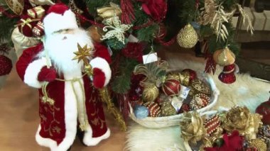 Ağacın altındaki karda komik oyuncak kardan adam. Parıldayan ışıklar arasında Noel ağacında Noel ve Yılbaşı oyuncakları.