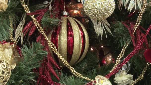 Boneco de neve de brinquedo engraçado na neve debaixo da árvore. Brinquedos de Natal e Ano Novo na árvore de Natal entre as luzes cintilantes . — Vídeo de Stock
