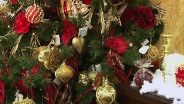 Jouet drôle bonhomme de neige dans la neige sous l'arbre. Noël et le Nouvel An jouets sur le sapin de Noël parmi les lumières scintillantes . — Video