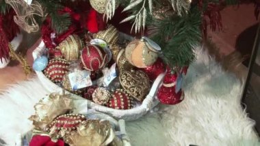 Ağacın altındaki karda komik oyuncak kardan adam. Parıldayan ışıklar arasında Noel ağacında Noel ve Yılbaşı oyuncakları.