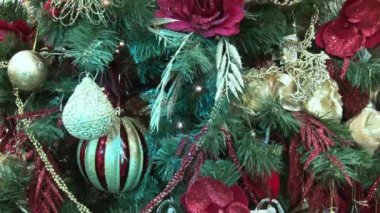 Ağacın altındaki karda komik oyuncak kardan adam. Parıldayan ışıklar arasında Noel ağacında Noel ve Yılbaşı oyuncakları.