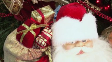 Ağacın altındaki karda komik oyuncak kardan adam. Parıldayan ışıklar arasında Noel ağacında Noel ve Yılbaşı oyuncakları.