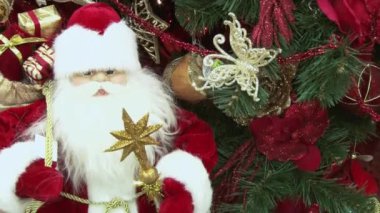 Ağacın altındaki karda komik oyuncak kardan adam. Parıldayan ışıklar arasında Noel ağacında Noel ve Yılbaşı oyuncakları.