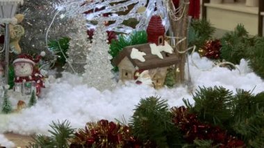 Ağacın altındaki karda komik oyuncak kardan adam. Parıldayan ışıklar arasında Noel ağacında Noel ve Yılbaşı oyuncakları.