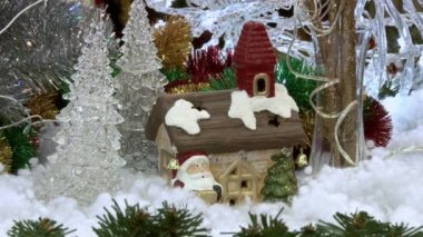 Ağacın altındaki karda komik oyuncak kardan adam. Parıldayan ışıklar arasında Noel ağacında Noel ve Yılbaşı oyuncakları.