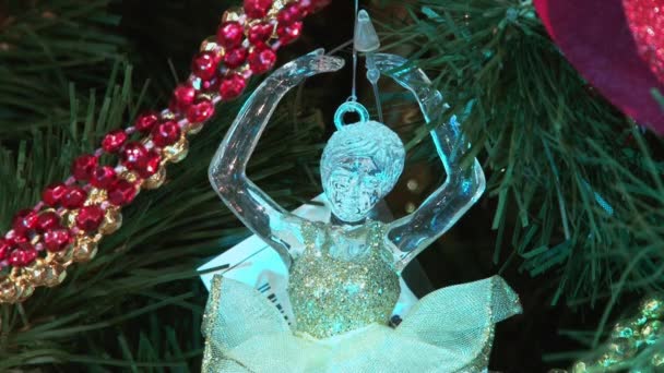 Juguete divertido muñeco de nieve en la nieve bajo el árbol. Juguetes de Navidad y Año Nuevo en el árbol de Navidad entre las luces centelleantes . — Vídeos de Stock