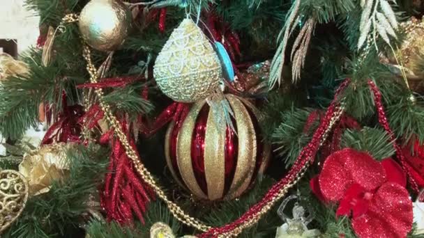 Brinquedo Papai Noel debaixo da árvore de presentes. Brinquedos de Natal e Ano Novo na árvore de Natal entre as luzes cintilantes . — Vídeo de Stock