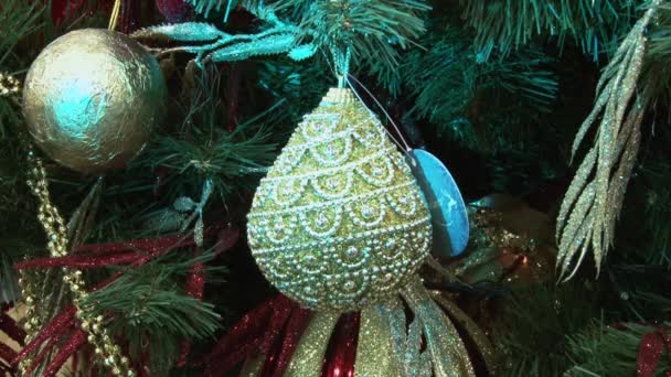 Juguete divertido muñeco de nieve en la nieve bajo el árbol. Juguetes de Navidad y Año Nuevo en el árbol de Navidad entre las luces centelleantes . — Vídeos de Stock