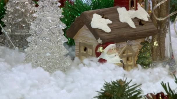 Juguete divertido muñeco de nieve en la nieve bajo el árbol. Juguetes de Navidad y Año Nuevo en el árbol de Navidad entre las luces centelleantes . — Vídeos de Stock