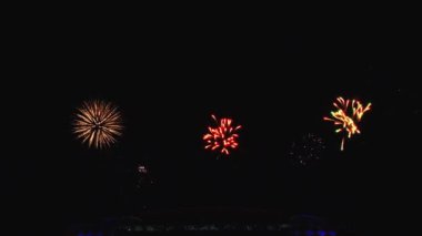 Gece gökyüzünde ve binalarda büyük şehirde güzel bir pyro gösterisi havai fişek.