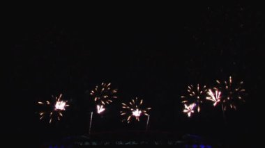 Gece gökyüzünde ve binalarda büyük şehirde güzel bir pyro gösterisi havai fişek.