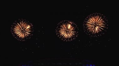 Gece gökyüzünde ve binalarda büyük şehirde güzel bir pyro gösterisi havai fişek.