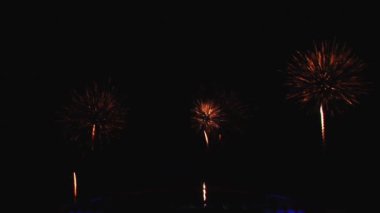 Gece gökyüzünde ve binalarda büyük şehirde güzel bir pyro gösterisi havai fişek.