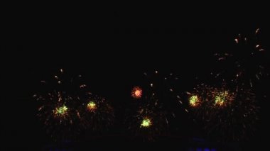 Gece gökyüzünde ve binalarda büyük şehirde güzel bir pyro gösterisi havai fişek.