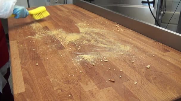 Rengöring av träbord från brödsmulor gul borste. — Stockvideo