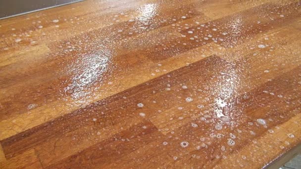 Применение чистящей жидкости к поверхности деревянного стола . — стоковое видео
