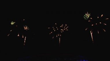 Gece gökyüzünde ve binalarda büyük şehirde güzel bir pyro gösterisi havai fişek.