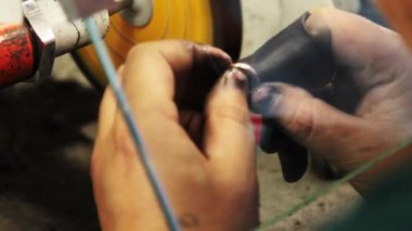 Bir taşlama tekerleği üzerinde fırçalanmış altın takı.