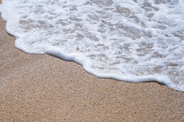 Kumsalda kumların üzerinden dalga geçiyor. Üstten aşağı görünüm, kapat.