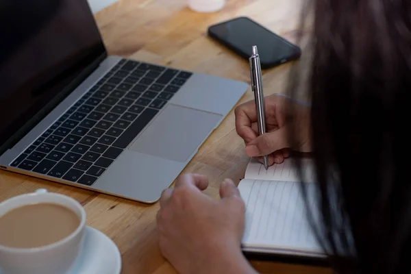 Woman Working Home Writing Notepad Laptop Smartphone Coffee Wooden Desk — Zdjęcie stockowe