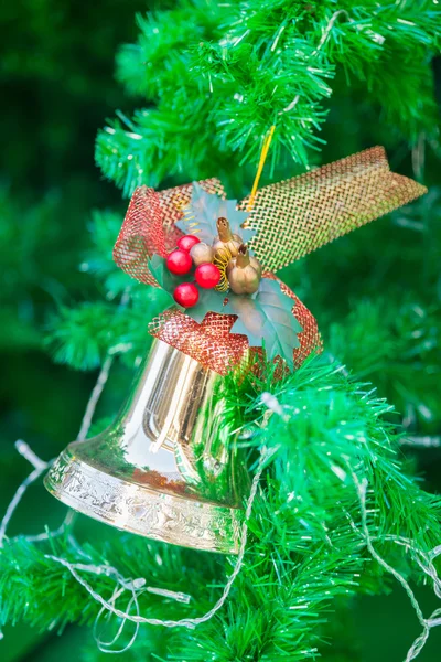 Χρυσή καμπάνα με κόκκινη κορδέλα στολίδι στο χριστουγεννιάτικο δέντρο — Φωτογραφία Αρχείου