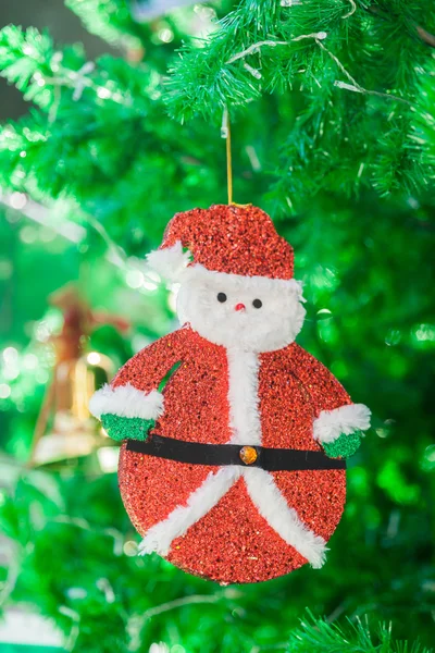 Bonito boneca de Papai Noel e ornamento sino de ouro na árvore de Natal — Fotografia de Stock