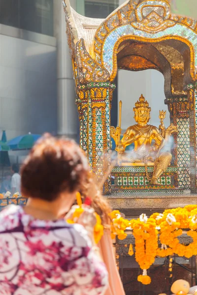 Kvinnan turist be på Erawan Shrine Royaltyfria Stockfoton