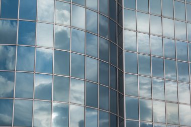 Bulutlu mavi gökyüzü yansıtan modern bina cam cephe
