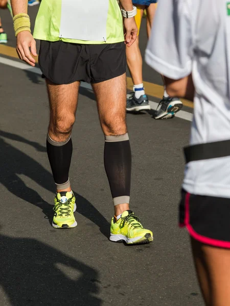 Спортсмен разогревается на городской улице перед бегом в городском марафо — стоковое фото