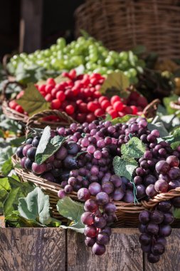 Hasır sepet ahşap raf içinde renkli üzüm demet