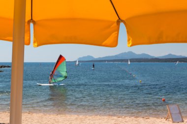 Plaj şemsiyesi, Rüzgar Sörfü, tepeler ve deniz arka planda sarı