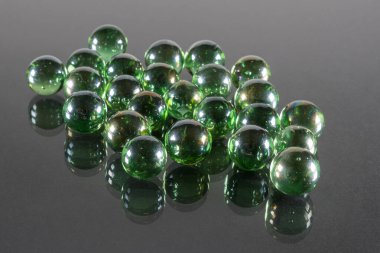 Yansıma ve Siyah Arkaplan ile Küçük Zümrüt Yeşil Cam Toplar.