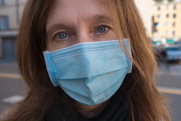 Close-up of a Middle-aged Lady with a Surgical Mask Outdoors.