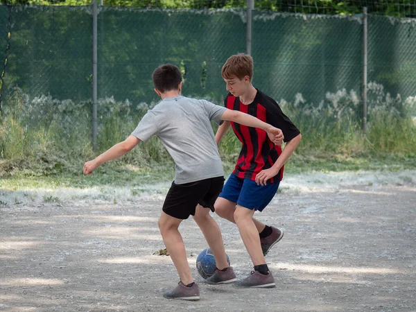 ほこりの多いフィールドでサッカーをしている2人の十代の男の子 — ストック写真