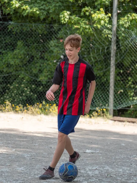ほこりの多いフィールドでサッカーをしている10代の男の子 — ストック写真