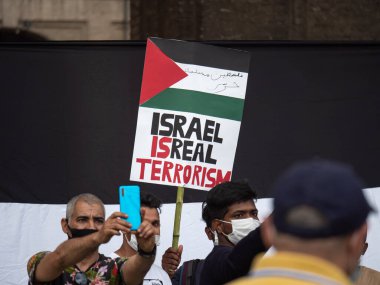 Filistin Bayrağı Toplantısı sırasında cerrahi maskeli Filistinli Adamlar selfie çekiyor.