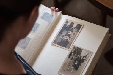 Eski Siyah ve Beyaz Vintage Fotoğraflara Bakan Kadın Bir Fotoğraf Albümünün Sayfalarını Yazıyor.