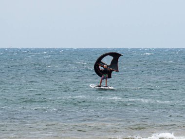 Rüzgarlı bir günde dalgalı bir denizde sörf yapmak..