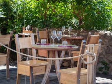 Boş Ahşap Masalar ve Kristal Şarap Tadım Gözlükleri İtalya 'daki Toskana Köyünde Açık Öğle Yemeği için.