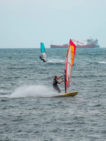 Windsurf Laranja Azul Montando Ondas Mar Choppy Barco Grande Fundo — Fotografia de Stock